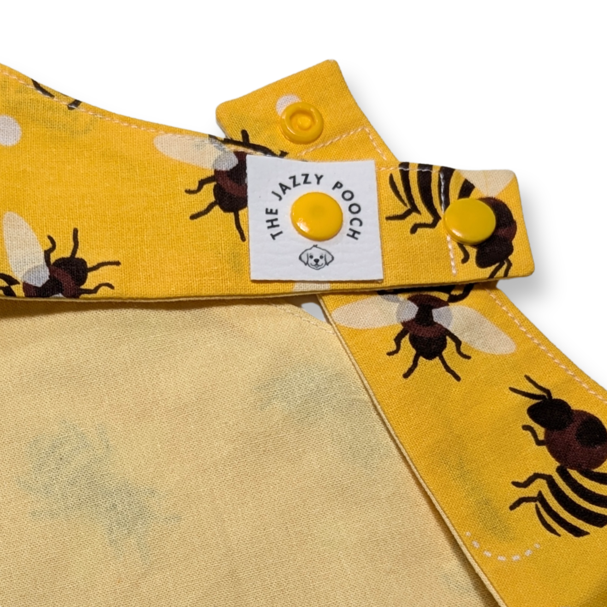 Close-up of The Jazzy Pooch branded label and adjustable snap-on poppers on handmade eco-friendly dog bandana - The Jazzy Pooch
