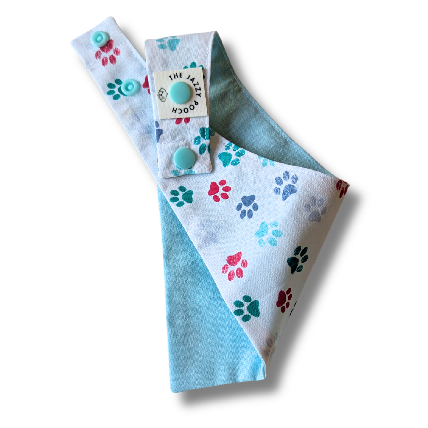Reversible dog bandana displaying festive Christmas pawprint pattern and cool turquoise blue reverse, handcrafted from sustainable reclaimed fabric - The Jazzy Pooch