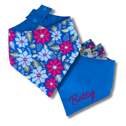 Handcrafted reversible dog bandana displaying festive poinsettia flowers on one side and royal blue on reverse, eco-friendly snap-on design - The Jazzy Pooch