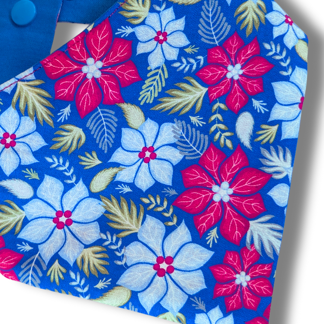 Close-up detail of vibrant Christmas poinsettia pattern on sustainable cotton dog bandana with adjustable poppers - The Jazzy Pooch